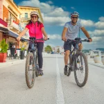 Active couple riding an E-Bike during vacations in the south