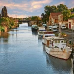 Saint-Gilles, Gard, Okzitanien, Frankreich: Wasserstraße mit Booten in der Stadt am Rande der Camargue