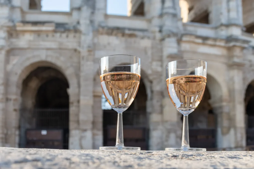 Französischer Roséwein aus der Provence in zwei Gläsern an einem sonnigen Tag mit Blick auf die alten Straßen der Stadt Arles an einem sonnigen Tag