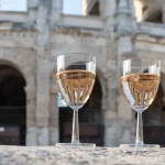 Französischer Roséwein aus der Provence in zwei Gläsern an einem sonnigen Tag mit Blick auf die alten Straßen der Stadt Arles an einem sonnigen Tag