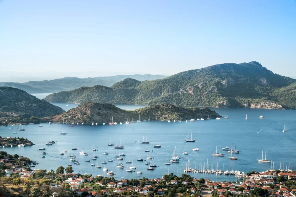 Selimiye village and Selimiye bay on Bozburun peninsula near Marmaris resort town in Mugla province on the south west coast of Turkey, bird's eye view. Many sailboats and yacht boats in the sea.