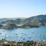 Selimiye village and Selimiye bay on Bozburun peninsula near Marmaris resort town in Mugla province on the south west coast of Turkey, bird's eye view. Many sailboats and yacht boats in the sea.