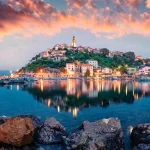 Breathtaking evening cityscape of Vrbnik town. Dramatic summer seascape of Adriatic sea, Krk island, Croatia, Europe. Beautiful world of Mediterranean countries. Traveling concept background.