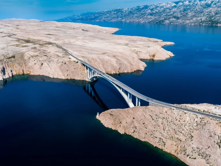 Ponte verso l'isola di Pag e il mare Adriatico e la catena montuosa del Velebit, Jadransko more, Croazia, ripresa aerea con drone