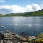 View across Calgary Bay, Isle of Mull, Scotland with clouds reflected in the calm blue waters of the Bay