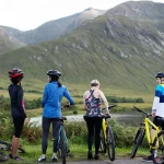 Group of cyclists by the riverside in the Highlands