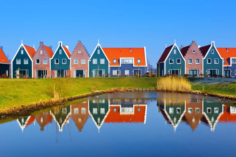 Farvede huse i marineparken i Volendam spejler sig i vandet, Holland