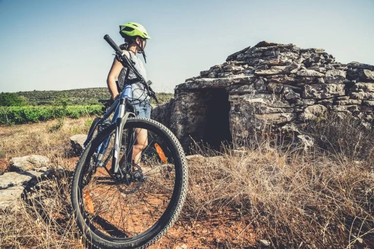 Donna viaggiatrice in bicicletta nel sito storico della piana di Stari Grad, patrimonio mondiale dell'UNESCO nell'isola di Hvar, Dalmazia, Croazia